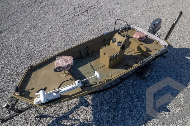 Slide: The Image of 2003 Polar Kraft Sportsman MV1885CC boat on gravel, featuring camouflage seats and motor. - 45