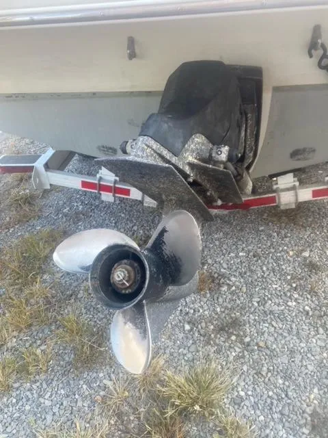 Slide: The Image of 1993 Chris-Craft Select Cuddy boat propeller and trailer on gravel surface. - 12
