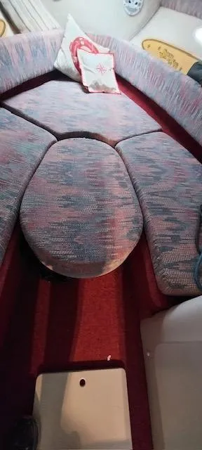 Slide: The Image of 1993 Chris-Craft Select Cuddy interior with cushioned seating and decorative pillow. - 5