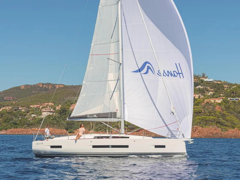 Slide: The Image of 2025 Hanse 410 sailboat cruising on a scenic coastal waterway. - 29