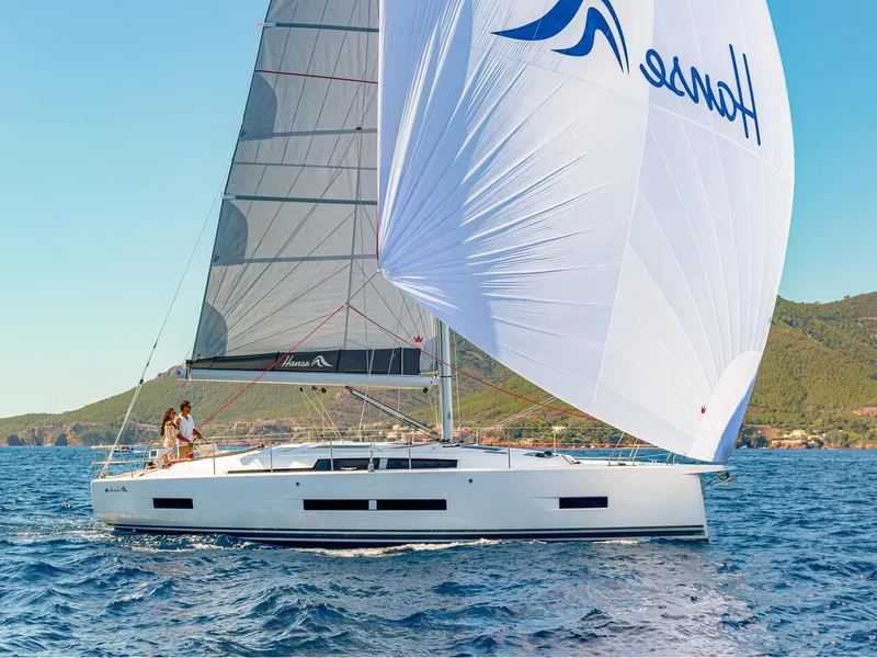 Slide: The Image of 2025 Hanse 410 yacht sailing on open water with scenic coastal backdrop. - 38