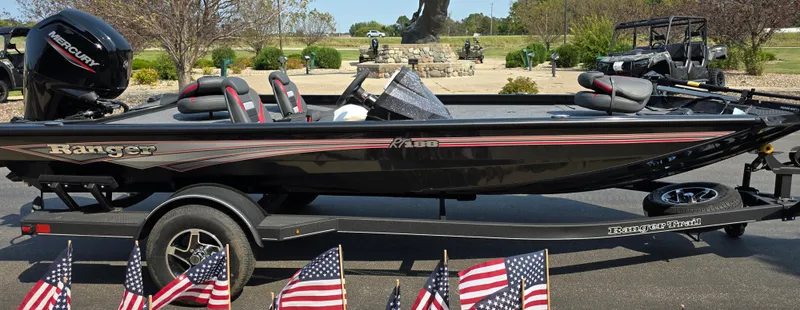 Slide: The Image of 2024 Ranger RT188 boat on trailer with American flags in foreground. - 1