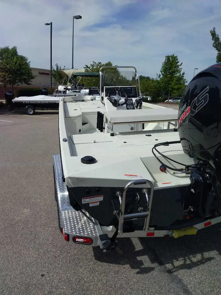Slide: The Image of 2024 Ranger RB200 boat with motor, parked outdoors on a sunny day. - 5