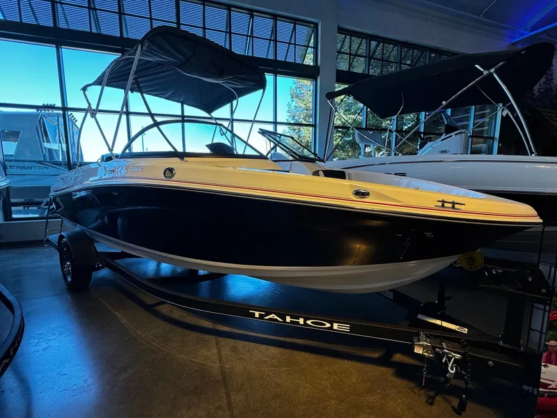 The Image of 2024 Tahoe 200 S boat in showroom with canopy and trailer. - 0