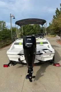 Slide: The Image of 2024 Tahoe T16 boat with outboard motor on a trailer, parked on a sunny driveway. - 1