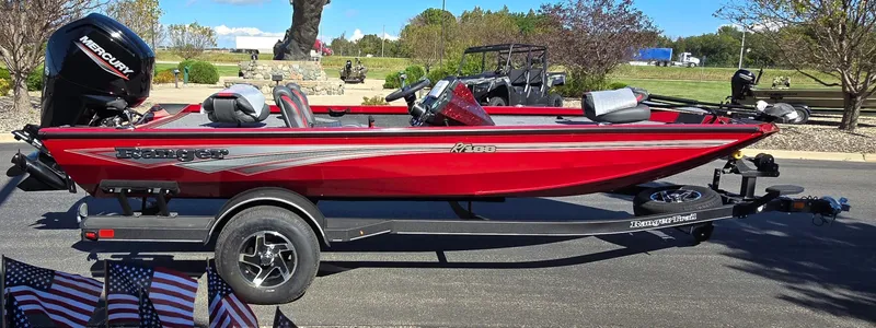 Slide: The Image of 2024 Ranger RT188 red fishing boat on trailer, parked outdoors. - 2