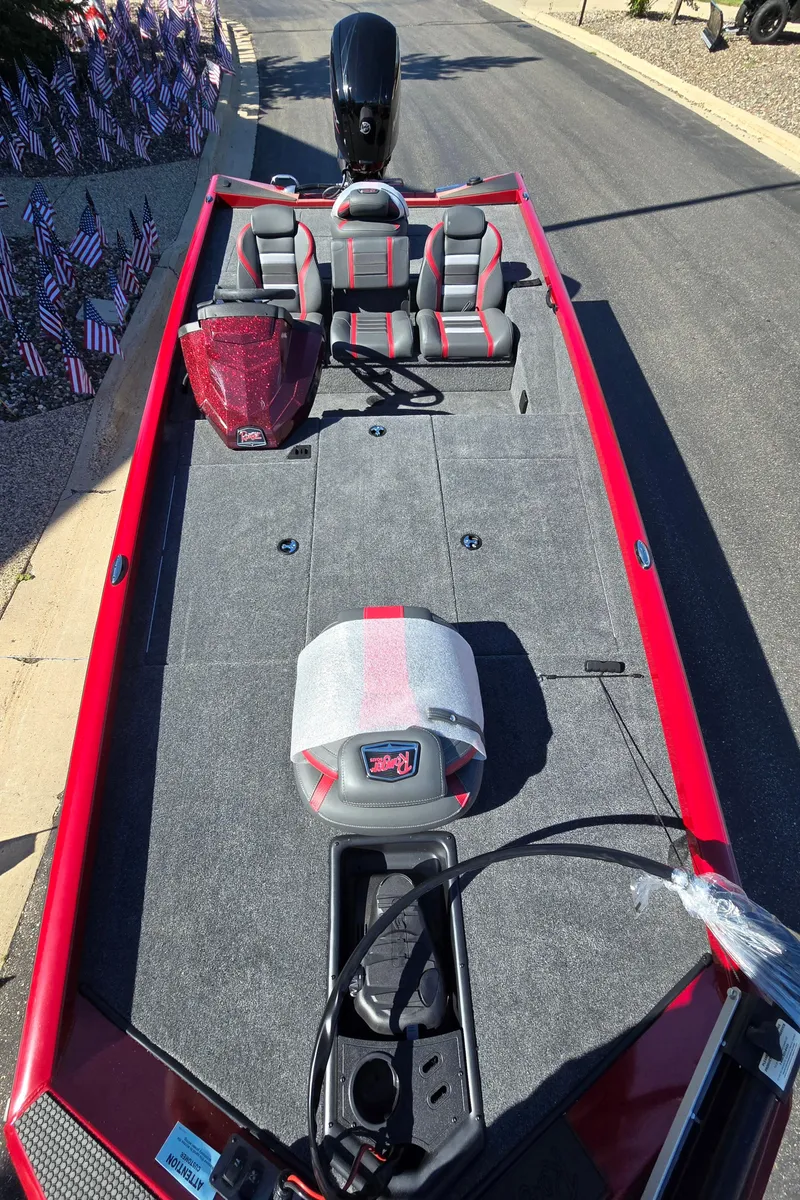 Slide: The Image of 2024 Ranger RT188 boat, red and gray interior, parked on a sunny street. - 6