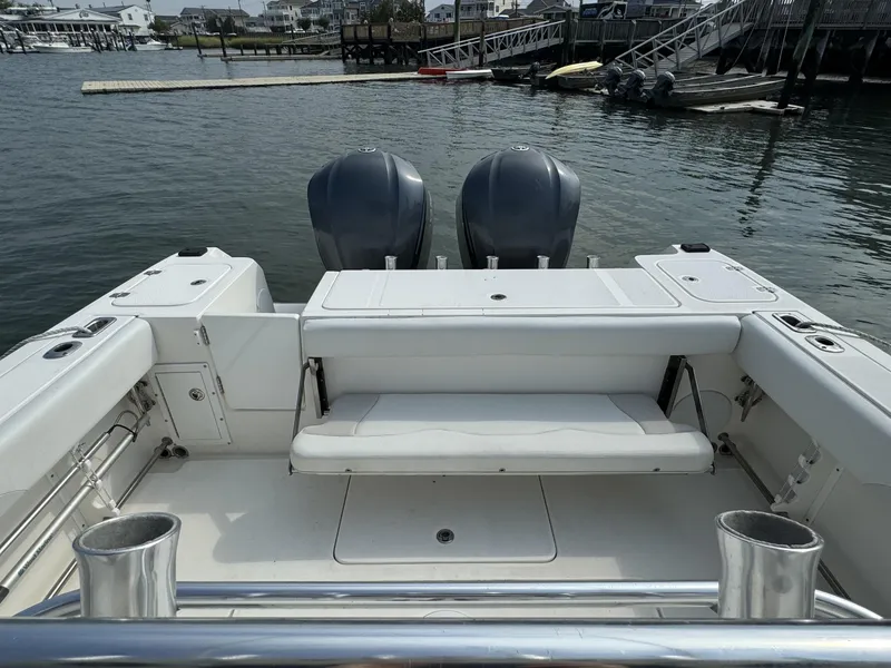 Slide: The Image of 2013 Edgewater 318 CC boat interior with dual engines, docked in a marina. - 11