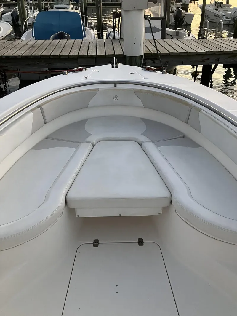 Slide: The Image of 2013 Edgewater 318 CC boat interior with cushioned seating at dock. - 3