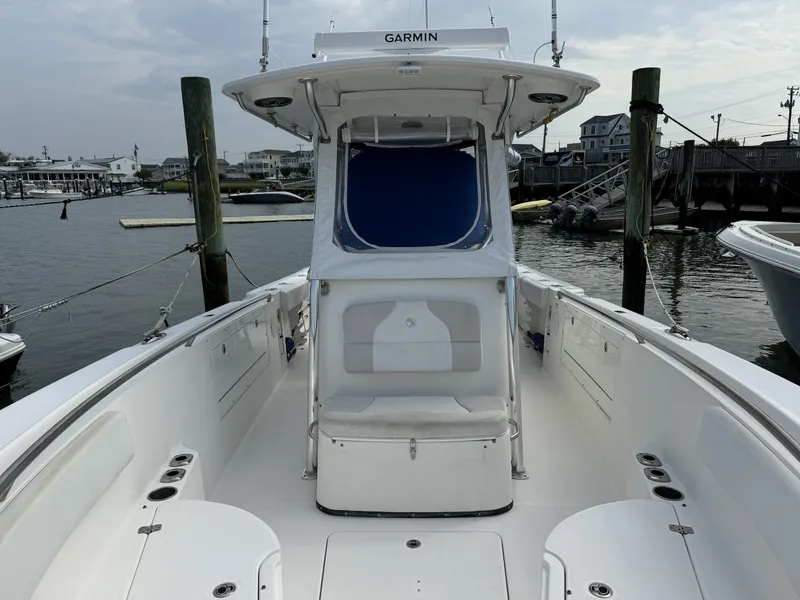 Slide: The Image of 2013 Edgewater 318 CC boat docked at marina, featuring spacious deck and Garmin equipment. - 4