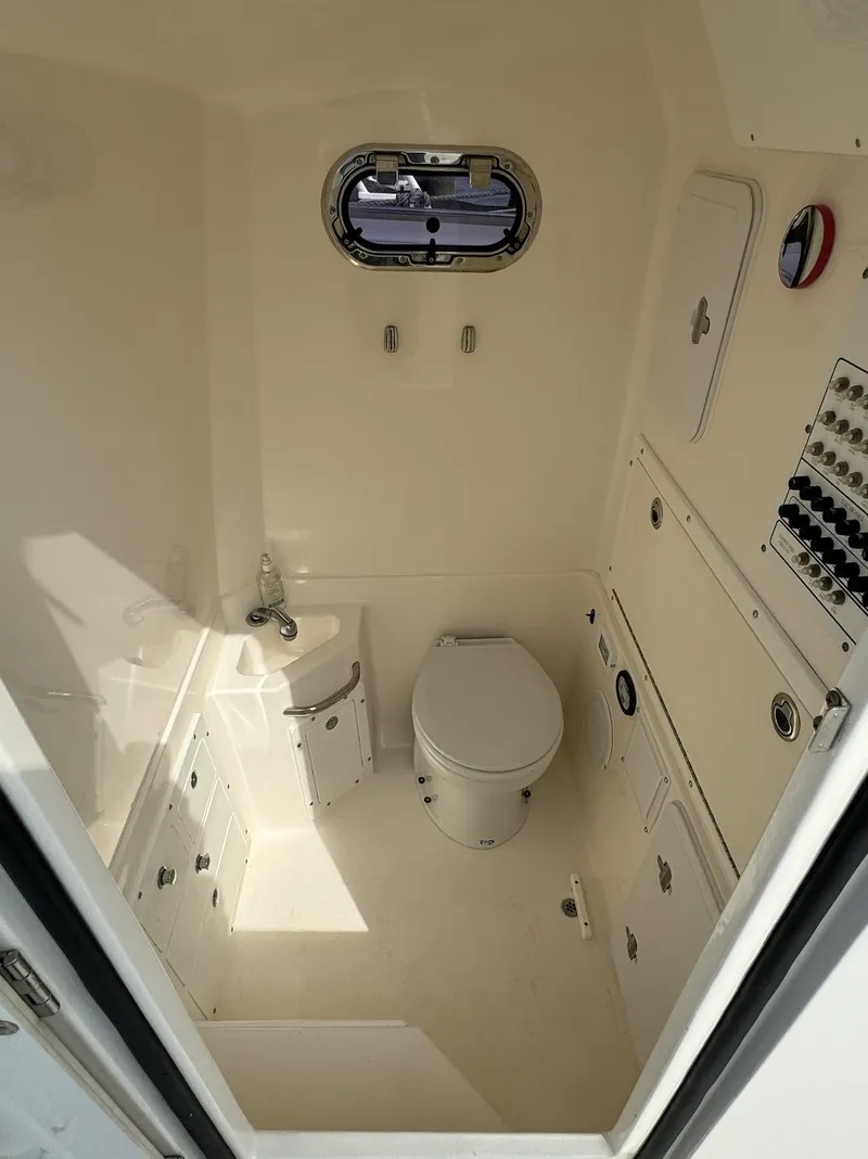 Slide: The Image of Interior of 2013 Edgewater 318 CC boat bathroom with toilet and sink. - 8