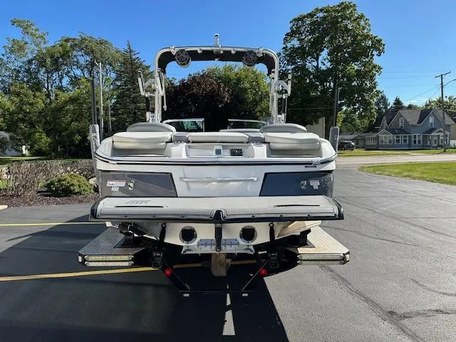 Slide: The Image of 2016 MasterCraft X46 boat parked on asphalt, rear view, sunny day. - 2