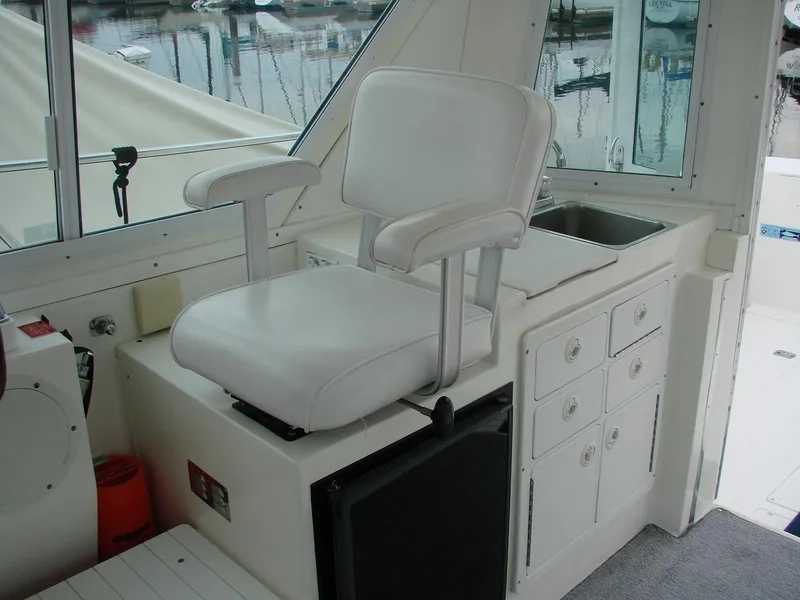 Slide: The Image of 2005 Albin Tournament Express interior with white captain's chair and storage cabinets. - 14