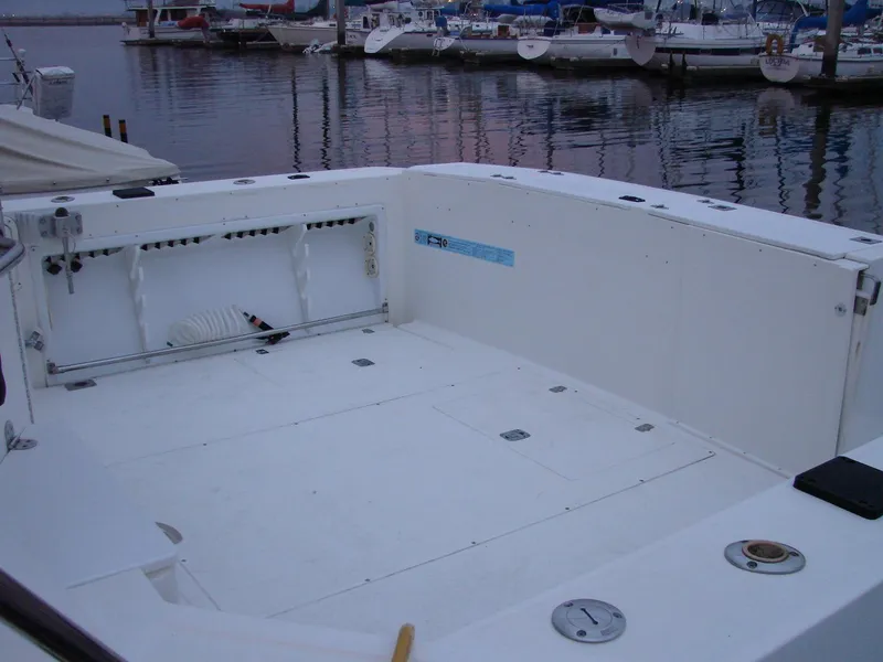 Slide: The Image of 2005 Albin Tournament Express boat deck at marina, featuring spacious white interior. - 21