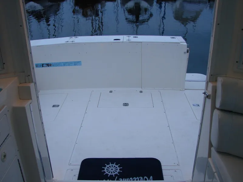 Slide: The Image of 2005 Albin Tournament Express boat deck with open hatch, docked on calm water. - 22