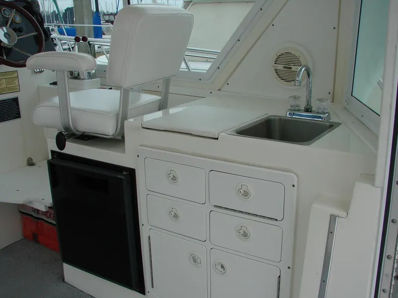 Slide: The Image of 2005 Albin Tournament Express interior with helm seat, sink, and storage drawers. - 24