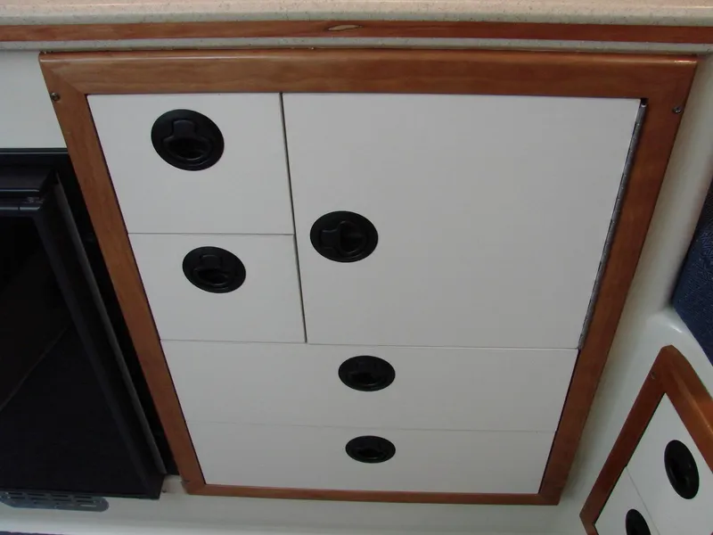 Slide: The Image of 2005 Albin Tournament Express interior cabinet with wooden trim and black handles. - 42