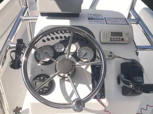 Slide: The Image of 2011 Carolina Skiff 258 DLV boat dashboard with steering wheel and control instruments. - 10