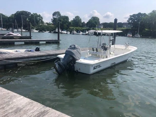 Slide: The Image of 2011 Carolina Skiff 258 DLV boat docked in a serene marina setting. - 5