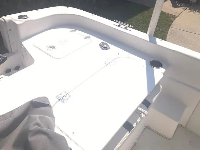 Slide: The Image of 2011 Carolina Skiff 258 DLV boat deck, white surface, storage compartments visible. - 9