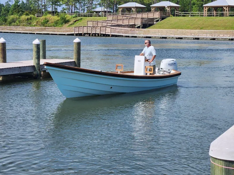 Slide: The Image of Man steering 2024 Caribiana Maracas boat on calm water near docks. - 5