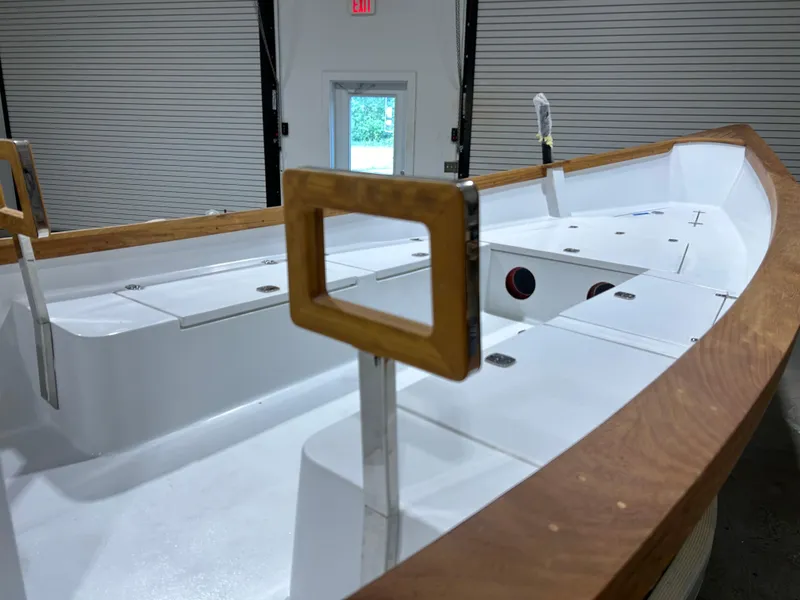 Slide: The Image of 2024 Caribiana Maracas boat interior with wooden trim and white seating. - 8