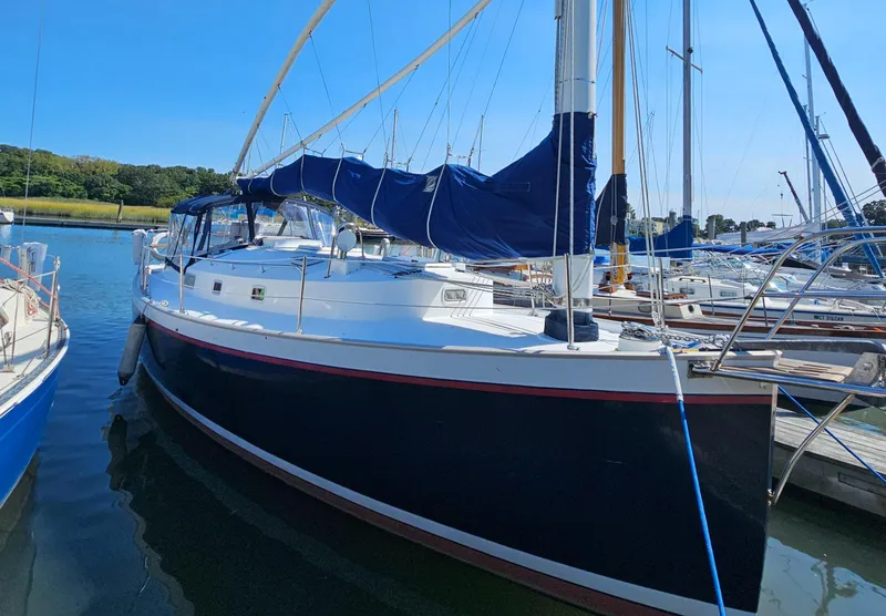 The Image of Nonsuch 33 sailboat, 2005 model, docked in a marina under clear blue skies. - 0