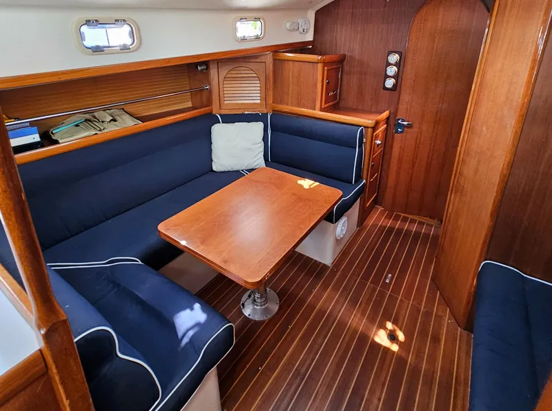 Slide: The Image of Interior of 2005 Nonsuch 33 sailboat with blue seating and wooden table. - 13