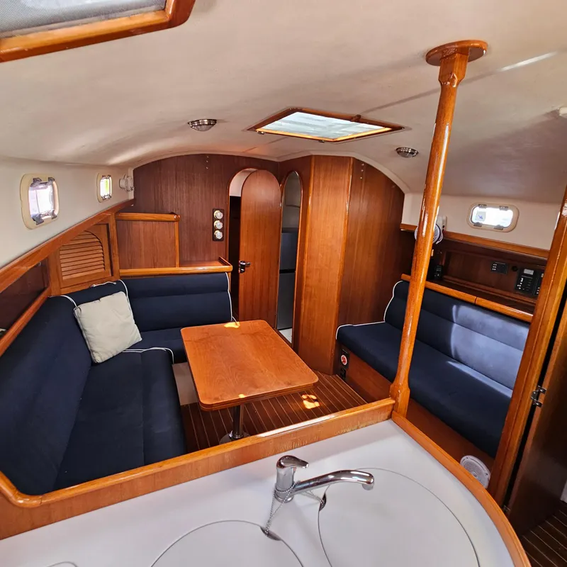 Slide: The Image of Interior of 2005 Nonsuch 33 sailboat with wooden furnishings and blue seating. - 14