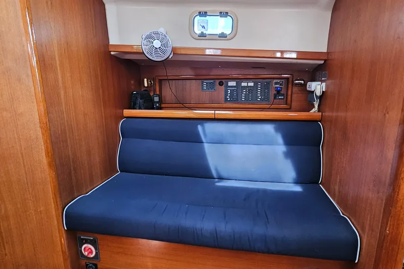 Slide: The Image of Interior of 2005 Nonsuch 33 sailboat with blue cushioned seating and control panel. - 15