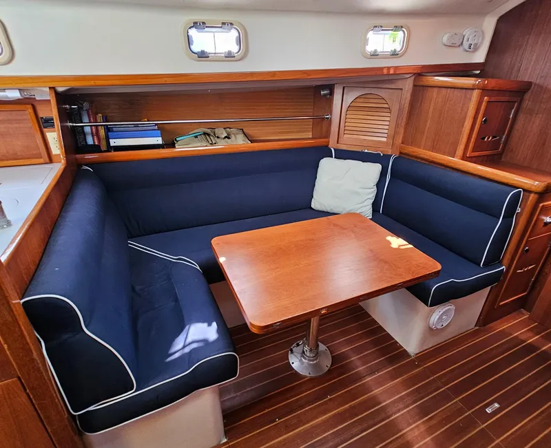 Slide: The Image of Cozy interior of 2005 Nonsuch 33 sailboat with blue cushioned seating and wooden table. - 16