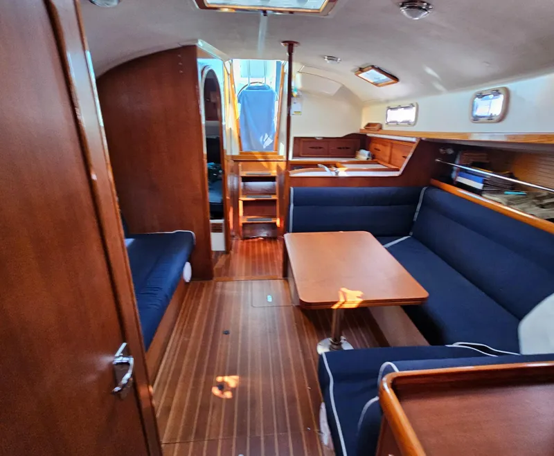 Slide: The Image of Interior of 2005 Nonsuch 33 sailboat with wooden furnishings and blue seating. - 17