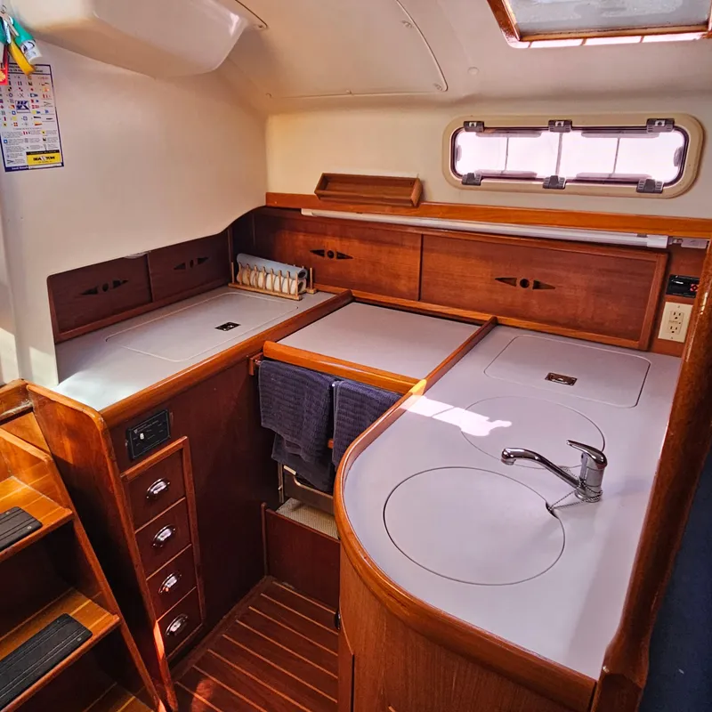 Slide: The Image of Interior of 2005 Nonsuch 33 sailboat galley with wood cabinetry and modern fixtures. - 18
