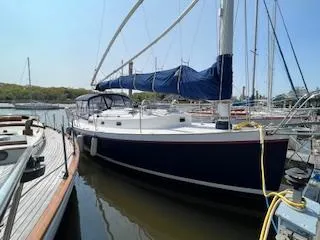 Slide: The Image of 2005 Nonsuch 33 sailboat docked at marina with blue hull and sail cover. - 2