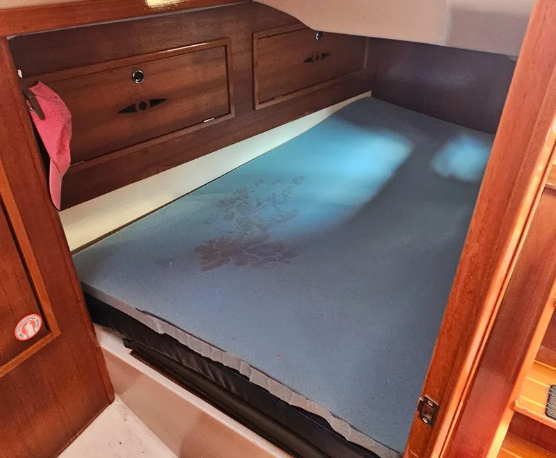 Slide: The Image of Cozy cabin bed in 2005 Nonsuch 33 sailboat with wooden storage cabinets. - 24