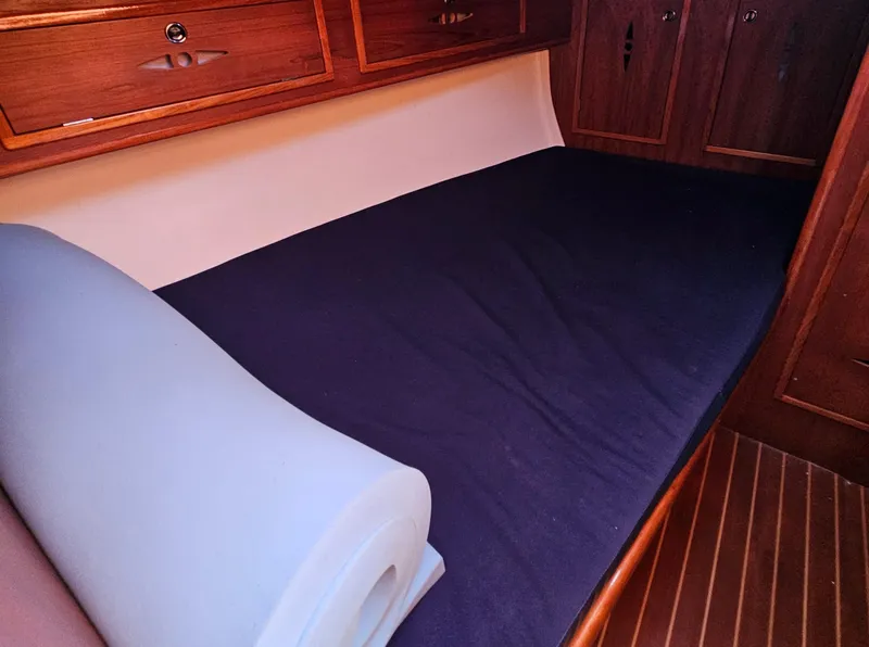 Slide: The Image of Interior cabin of a 2005 Nonsuch 33 sailboat with wooden cabinetry and bedding. - 25