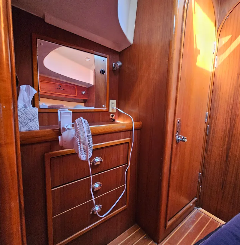 Slide: The Image of Interior of 2005 Nonsuch 33 sailboat with wooden cabinetry and small fan. - 27