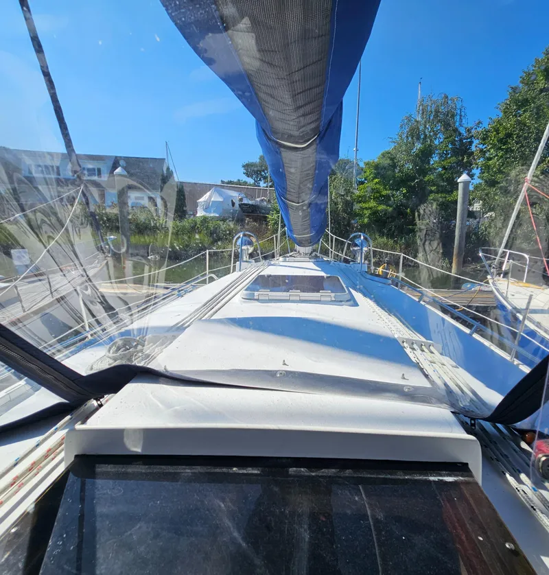 Slide: The Image of Nonsuch 33 sailboat deck view, 2005 model, with clear skies and marina backdrop. - 9