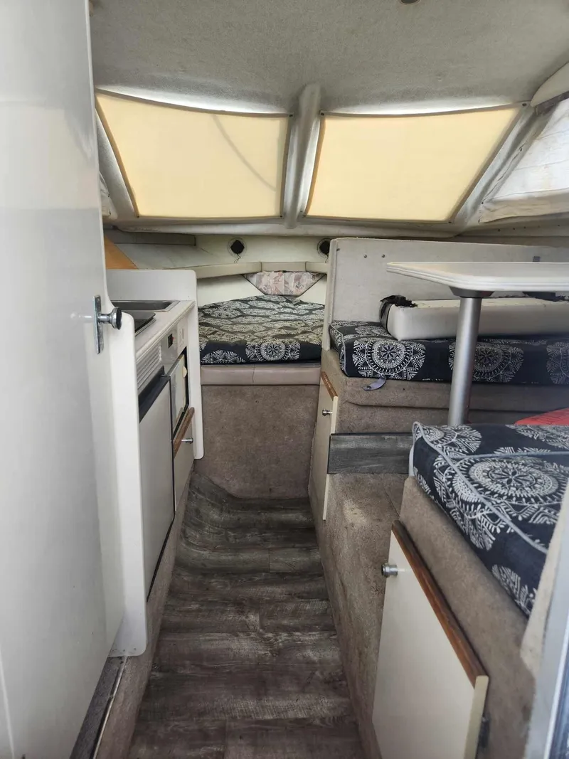 Slide: The Image of 1999 Bayliner 2452 Ciera Express cabin interior with seating and kitchenette. - 10