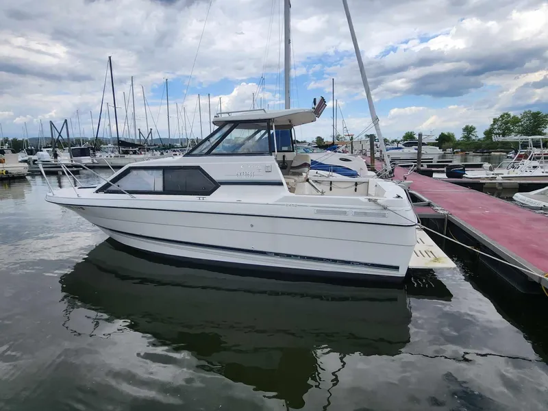 Slide: The Image of 1999 Bayliner 2452 Ciera Express boat docked at marina under cloudy sky. - 2