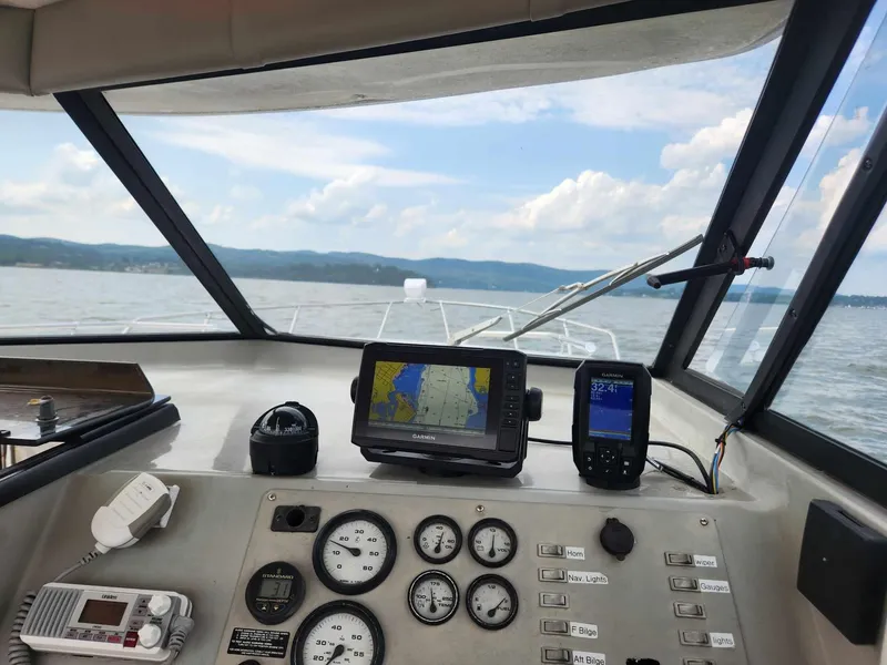 Slide: The Image of 1999 Bayliner 2452 Ciera Express dashboard with navigation equipment on a lake. - 4