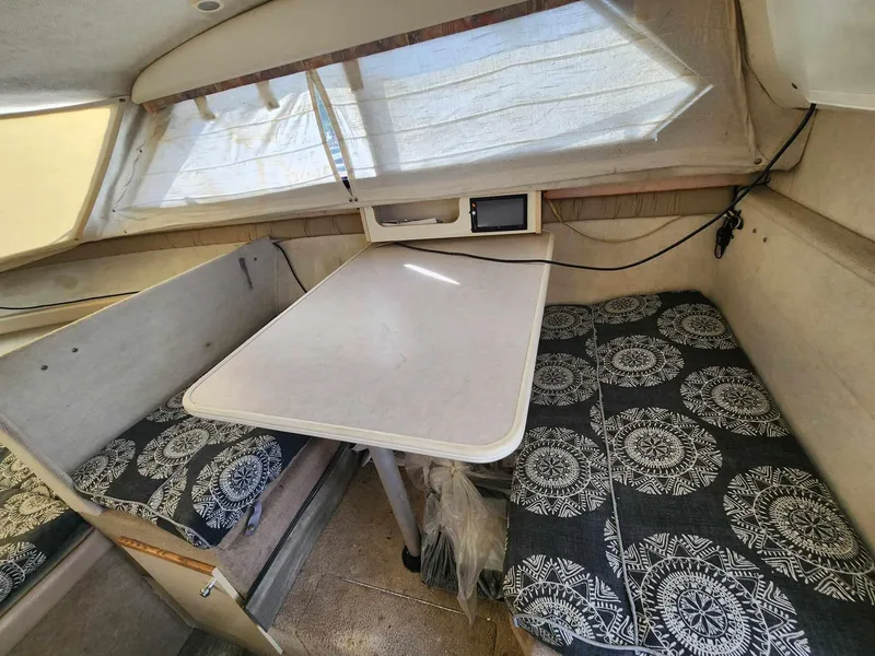 Slide: The Image of 1999 Bayliner 2452 Ciera Express cabin interior with table and patterned seating. - 7
