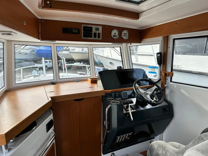 Slide: The Image of Interior of 2023 Sargo 28 boat, featuring modern helm and wooden cabinetry. - 13