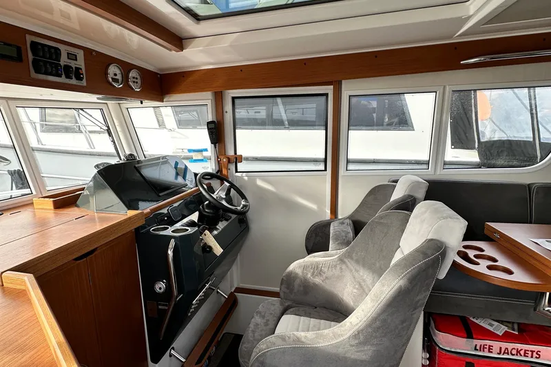 Slide: The Image of Interior of 2023 Sargo 28 boat with steering wheel and seating area. - 16