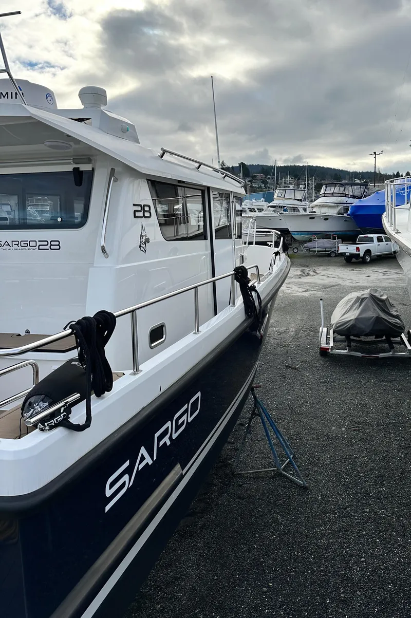 Slide: The Image of 2023 Sargo 28 boat docked at marina, overcast sky. - 6