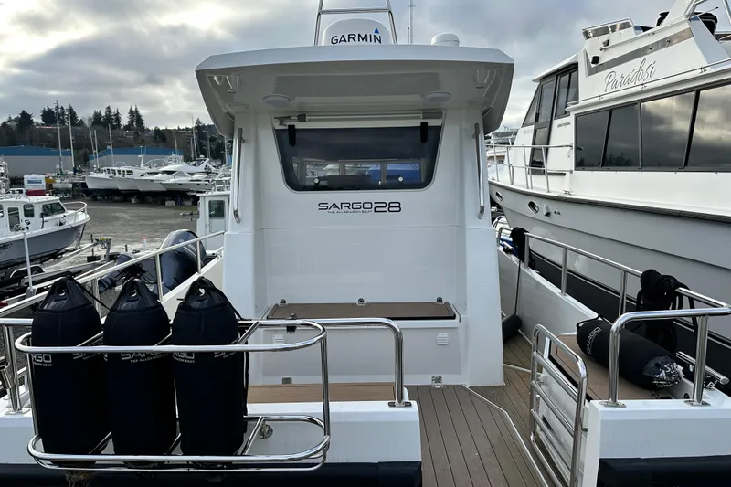 Slide: The Image of 2023 Sargo 28 boat docked at marina, rear view with fenders and deck. - 7