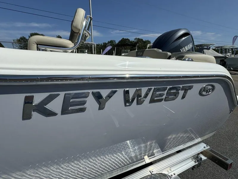 The Image of 2025 Key West 203 FS boat on trailer, parked outdoors, with Yamaha engine. - 2