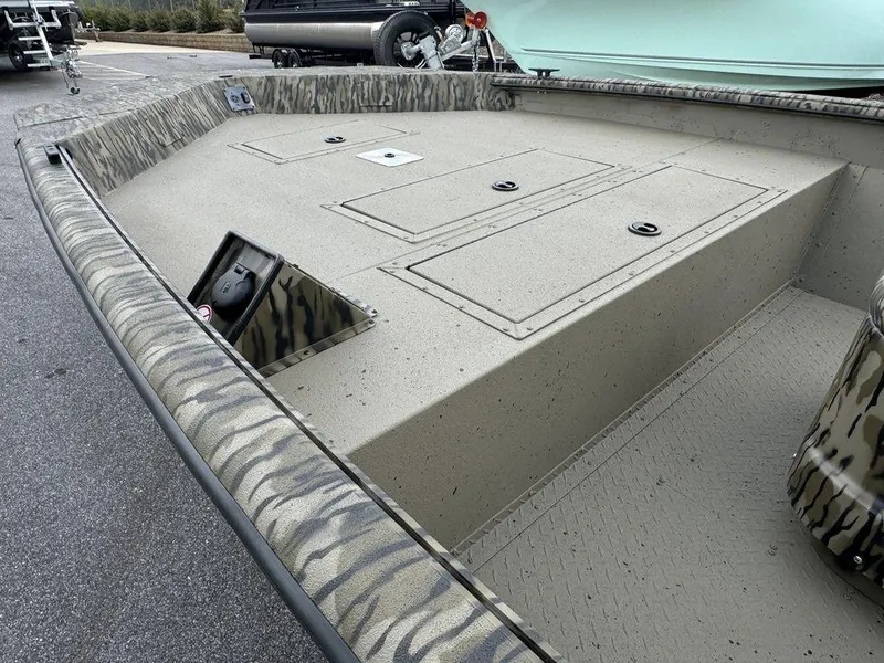 Slide: The Image of 2025 SeaArk Shadow 20 Elite CC boat with camouflage design, spacious deck, and storage compartments. - 11