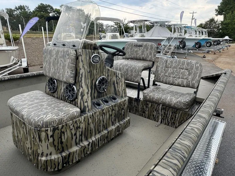 Slide: The Image of 2025 SeaArk Shadow 20 Elite CC boat with camouflage seating and console, displayed outdoors. - 12