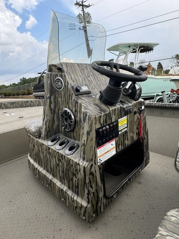 Slide: The Image of 2025 SeaArk Shadow 20 Elite CC boat console with camouflage design and steering wheel. - 13